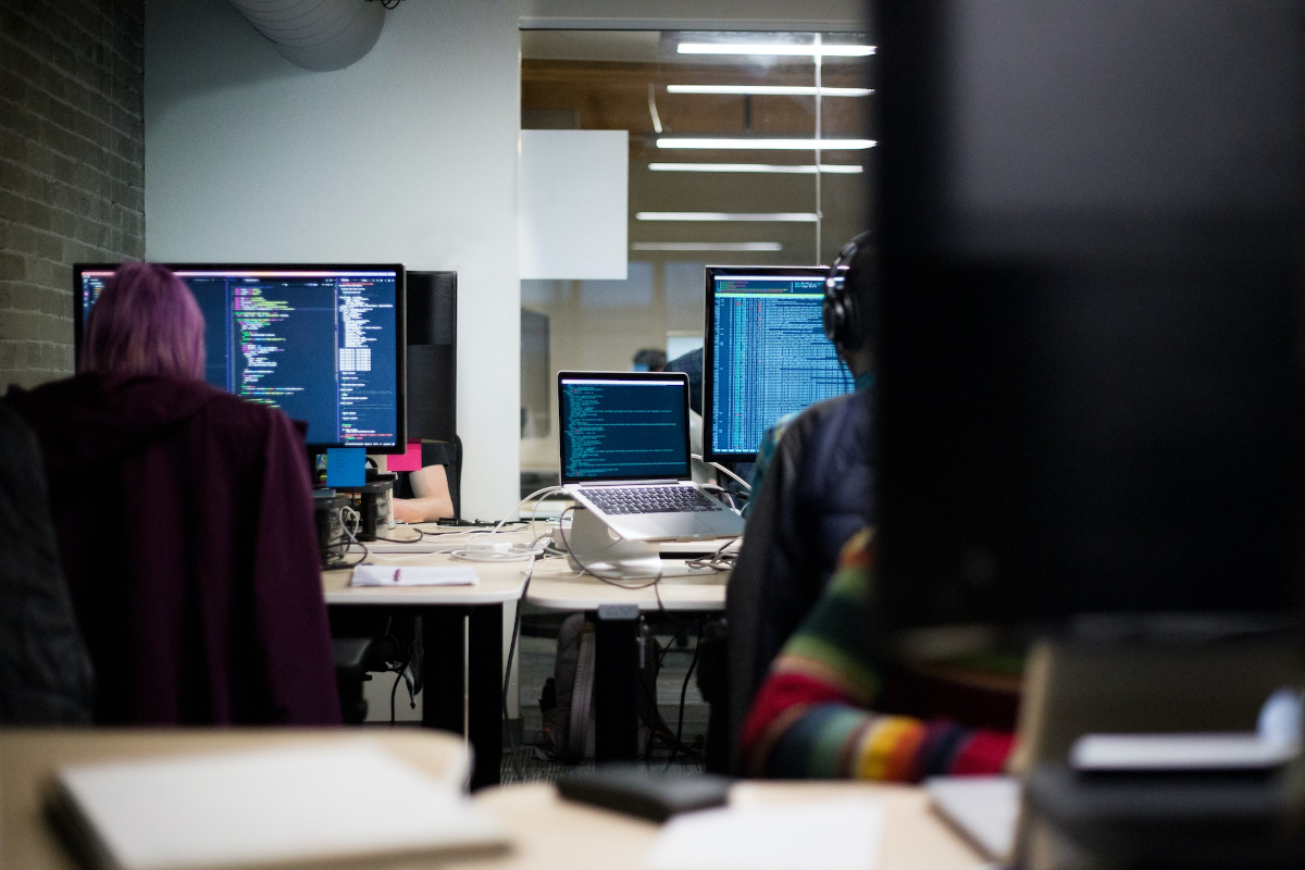 Office of people that are coding on computer screens