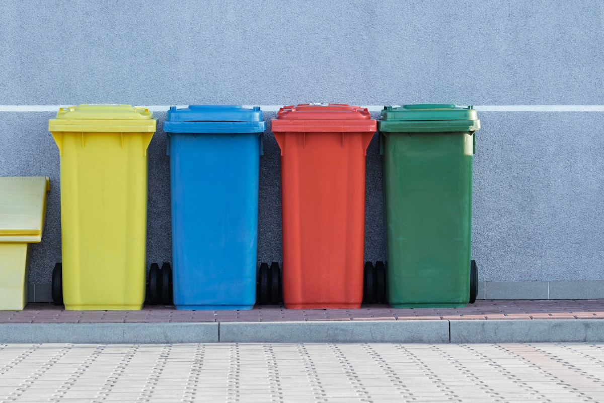 Different coloured recycling bins lined up outside