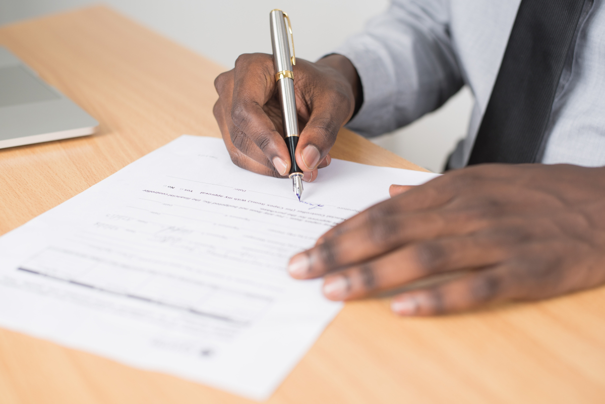 A man signing a document 